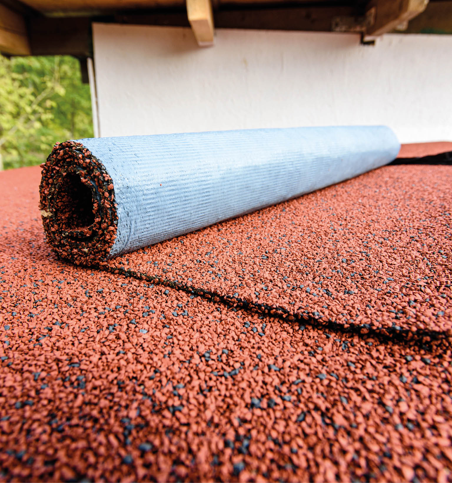 Red flexible roll tile on the roof of the house